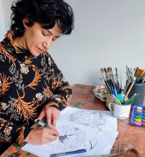 Virginia Costanzo en su taller Pachagonia dibujando las cartas del oraculo patagonico de cartas de poder de animales patagonicos 'memoria animal'